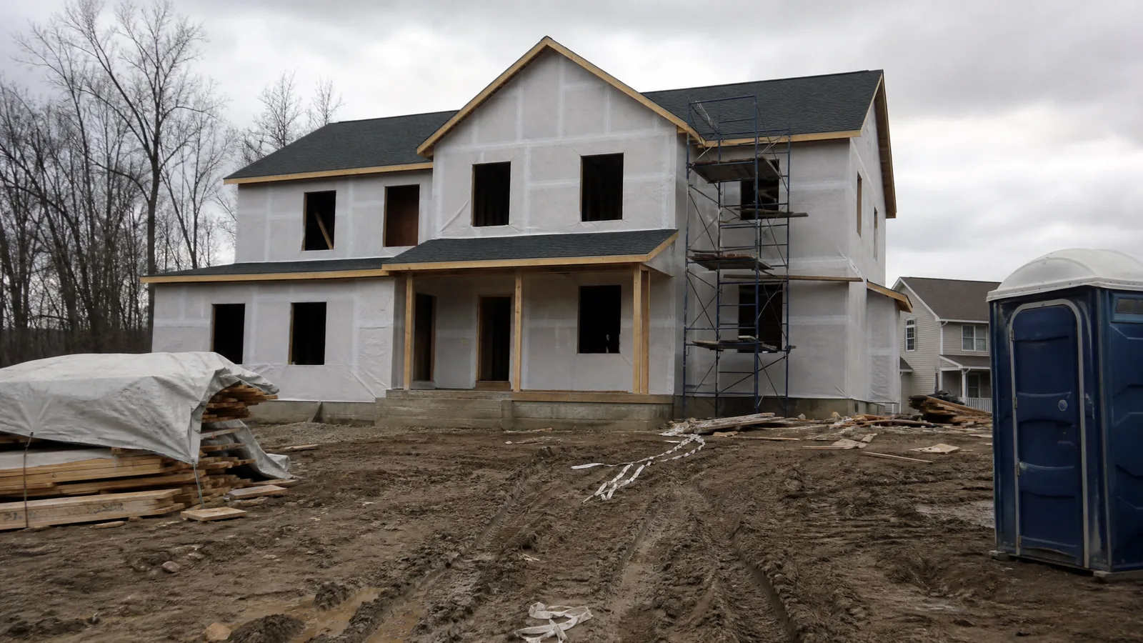 Two-story wood framed house at dry-in stage with sheathing, housewrap and window openings cut